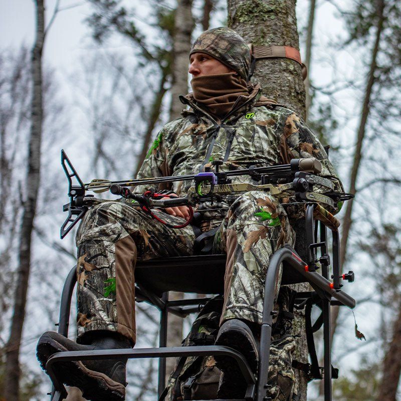 Whitetail bowhunter wearing the Altus Stealth Deer Hunting Suit in an autumn tree stand