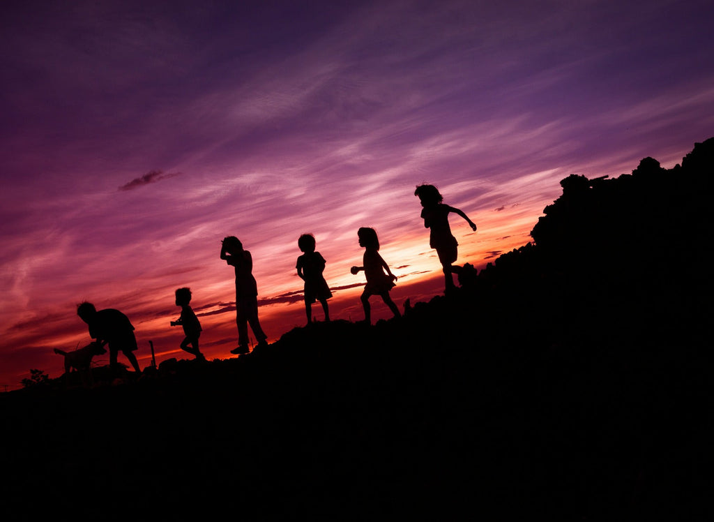 silouette of children running on hill