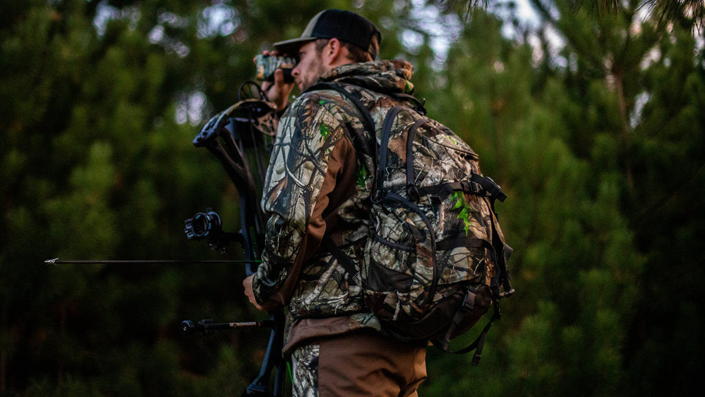 the hunter uses a rangefinder to search for his target deer