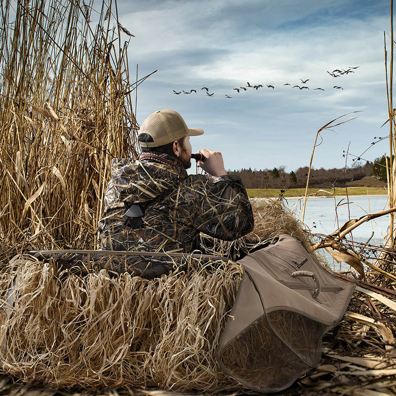 Duck hunter observing in the blind