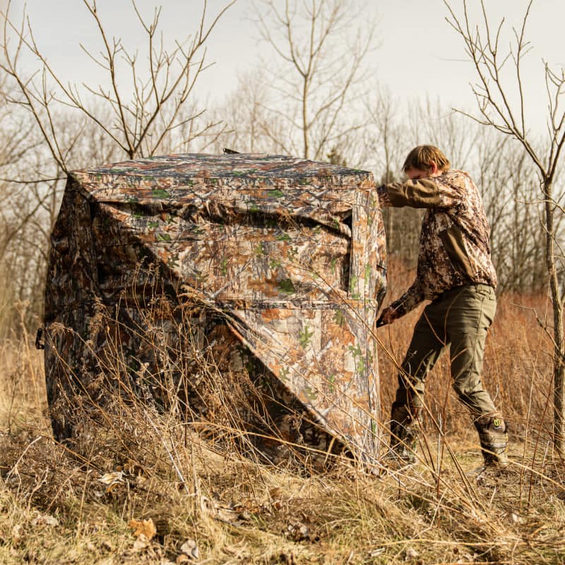 A hunter setting up the blind in the field